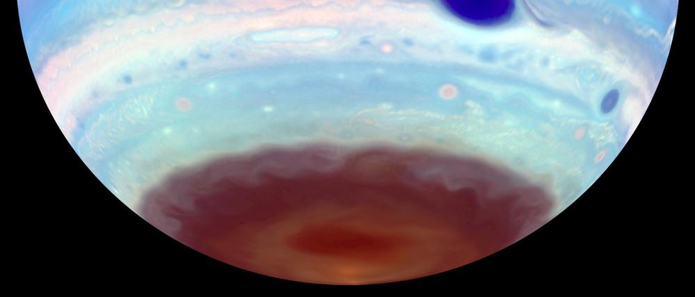 Im ultravioletten Licht erscheint der Große Rote Fleck des Jupiters blau. Im braunen Dunst am Südpol ist ein weiteres ovales Merkmal zu erkennen, wie sie auch regelmäßig, aber seltener am Nordpol auftreten.