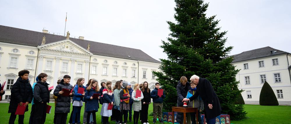 Das Startsignal: Bundespräsident Frank-Walter Steinmeier und seine Frau Elke Büdenbender entzünden zusammen mit einem Kind symbolisch die Beleuchtung am Weihnachtsbaum.