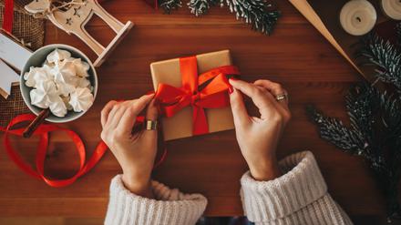 Eine Frau verpackt Geschenke für Weihnachten.