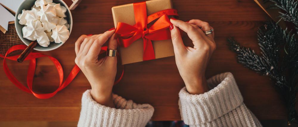 Eine Frau verpackt Geschenke für Weihnachten.