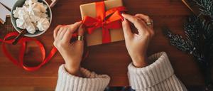 Eine Frau verpackt Geschenke für Weihnachten.