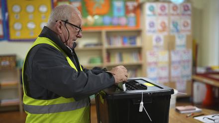 Ein Mann in Irland gibt seinen Stimmzettel für die Parlamentswahlen ab.  
