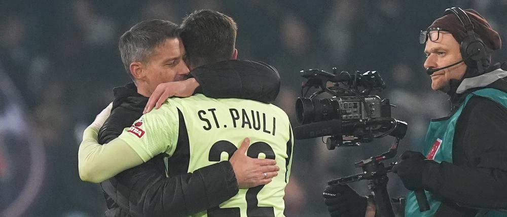 Endich ein Heimsieg. St. Paulis Trainer Alexander Blessin (l.) umarmt St. Paulis Torwart Nikola Vasilj nach Spielende.