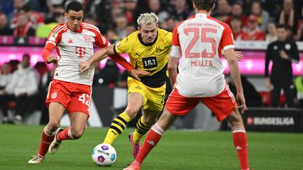 Klassiker. Bayerns Jamal Musiala (links), Dortmunds Julian Ryerson und Bayerns Thomas Müller im Kampf um den Ball. 