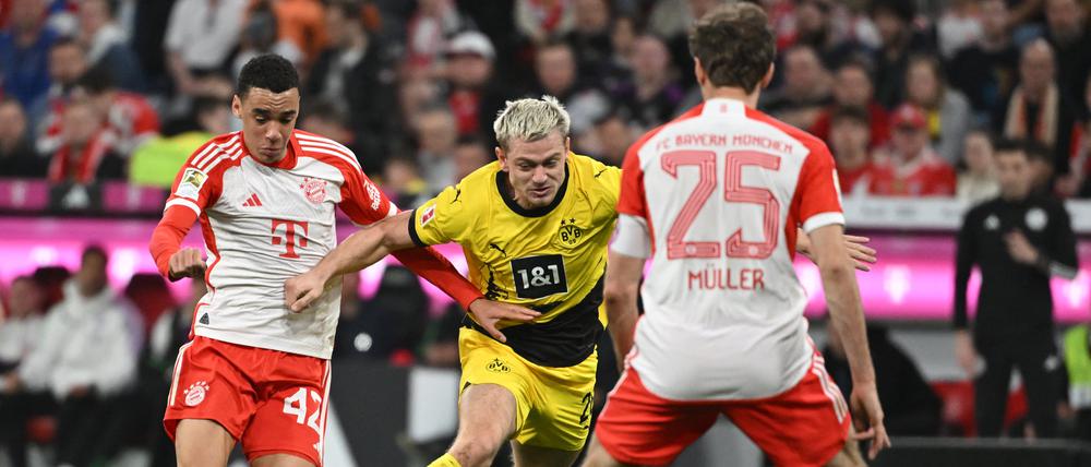 Klassiker. Bayerns Jamal Musiala (links), Dortmunds Julian Ryerson und Bayerns Thomas Müller im Kampf um den Ball. 