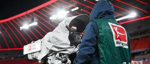 Ein Kameramann filmt ein Bundesligaspiel in der Allianz-Arena in München.