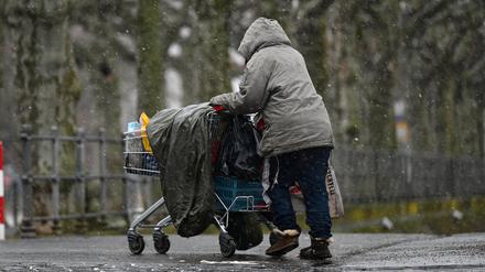 Eine obdachlose Frau schiebt ihr Hab und Gut in einem Einkaufswagen. (Symbolbild)