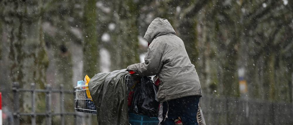 Eine obdachlose Frau schiebt ihr Hab und Gut in einem Einkaufswagen. (Symbolbild)