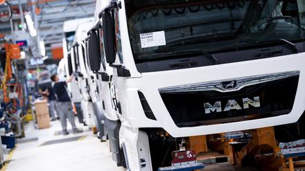 Mitarbeiter von MAN Truck & Bus arbeiten an einer Produktionsstraße an einem LKW im Jahre 2018.