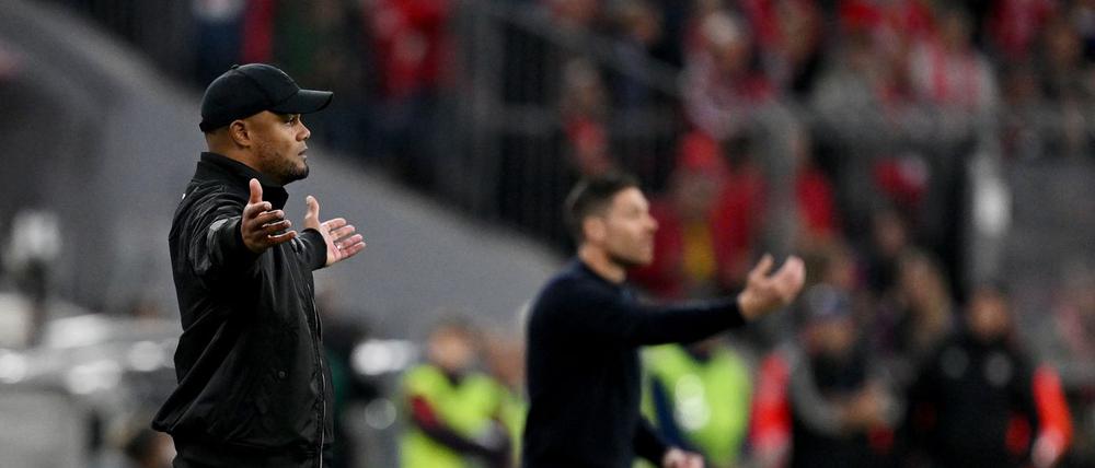 Schnelles Wiedersehen am Spielfeldrand: Bayern-Coach Vincent Kompany (M) und Leverkusens Meistertrainer Xabi Alonso (r).