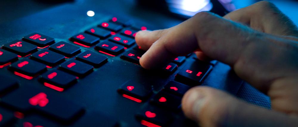 Ein Mann sitzt am Rechner und tippt auf einer Tastatur. 