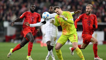 Manuel Neuer kommt zu spät und rammt Leverkusens Jeremie Frimpong um.