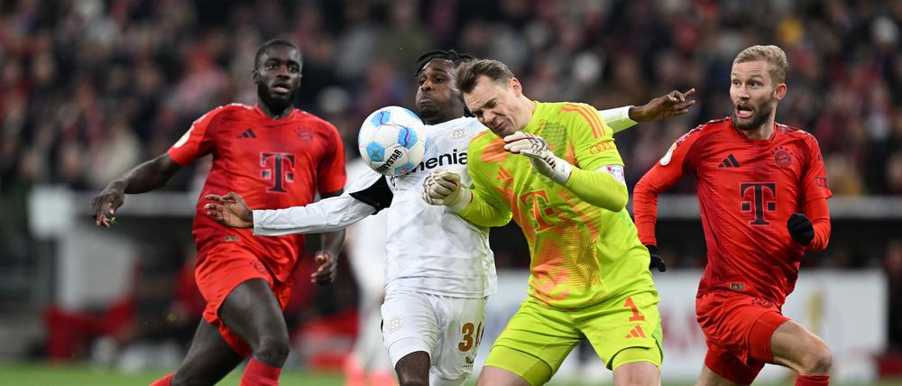 Manuel Neuer kommt zu spät und rammt Leverkusens Jeremie Frimpong um.