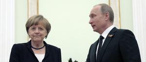 Die ehemalige Bundeskanzlerin Angela Merkel (l.) und der russische Präsident Wladimir Putin (r.) schütteln sich die Hände während ihrer Gespräche im Kreml. 