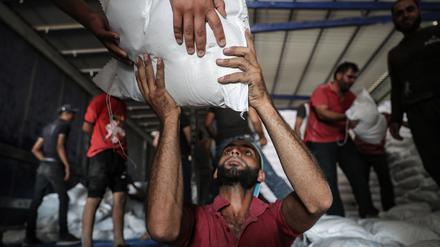 ARCHIV - 30.06.2021, Syrien, Bab Al-Hawa: Syrer lagern Pakete mit Lebensmitteln des Welternährungsprogramms der Vereinten Nationen (WFP), die zuvor mit LKWs aus der Türkei in den Nordwesten Syriens gebracht worden sind. Hilfsorganisationen und Menschenrechtler fordern vom US-Sicherheitsrat, die grenzüberschreitende Hilfe für notleidende Menschen in Syrien zu verlängern.