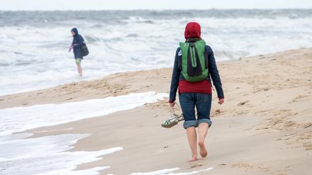 Besucher sind bei bewölktem Himmel und Temperaturen um 15 Grad Celsius am Strand von Westerland unterwegs (Symbolbild).