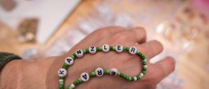 Delegierte basteln Armbänder mit dem Schriftzug «Kanzler Era» bei der Bundesdelegiertenkonferenz der Grünen.