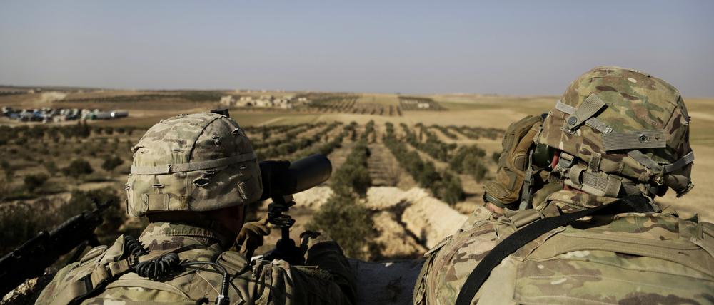 Zwei US-Soldaten schauen von ihrer Basis in Syrien zur türkischen Grenze hinüber. 