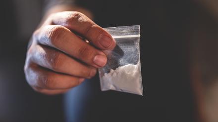 Eine Hand mit Tütchen voller Heroin.