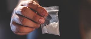 Eine Hand mit Tütchen voller Heroin.