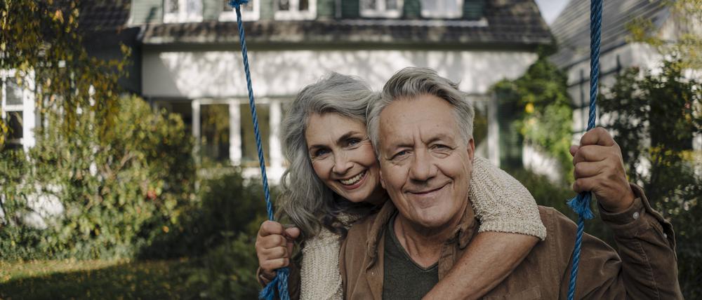 Portrait of a happy woman embracing senior man on a swing in garden model released Symbolfoto property released PUBLICATIONxINxGERxSUIxAUTxHUNxONLY GUSF03071