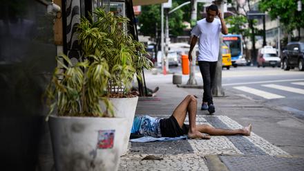 Ein Mann liegt in einer Nebenstraße unweit der Copacabana in Rio de Janeiro auf dem Bürgersteig. 