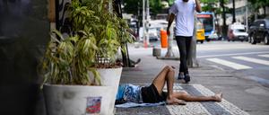 Ein Mann liegt in einer Nebenstraße unweit der Copacabana in Rio de Janeiro auf dem Bürgersteig. 