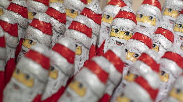 Schoko-Weihnachtsmänner stehen in einem Supermarkt.