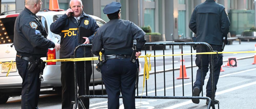 Polizisten stehen an einem abgesperrten Bereich am Eingang Hauses in der Nähe des Times Square. Am frühen Mittwochmorgen wurde einem 50-jährigen Mann vor dem Hotel und der Appartmentgebäude in der 6th Avenue in die Brust geschossen.