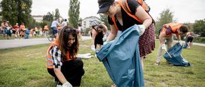 Hiral Arora (li.), Studentin aus Indien, und Camila Wolfram, aus Brasilien stammende Studentin in Berlin, sammeln bei einer Stadttour mit Müllsammeln im Mauerpark Müll. 