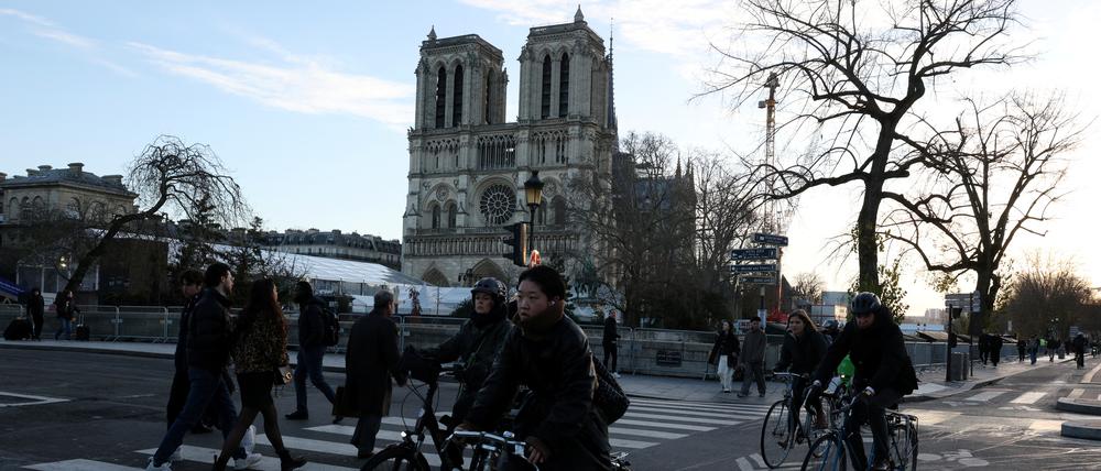 Radfahrer auf einem Radweg hinter der Kathedrale Notre-Dame in Paris.