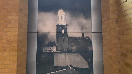 St. Nikolai, 1944, getroffen von Bomben. Der Kirchturm in der Altstadt in Flammen. Das Foto ist in der Zitadelle zu sehen.