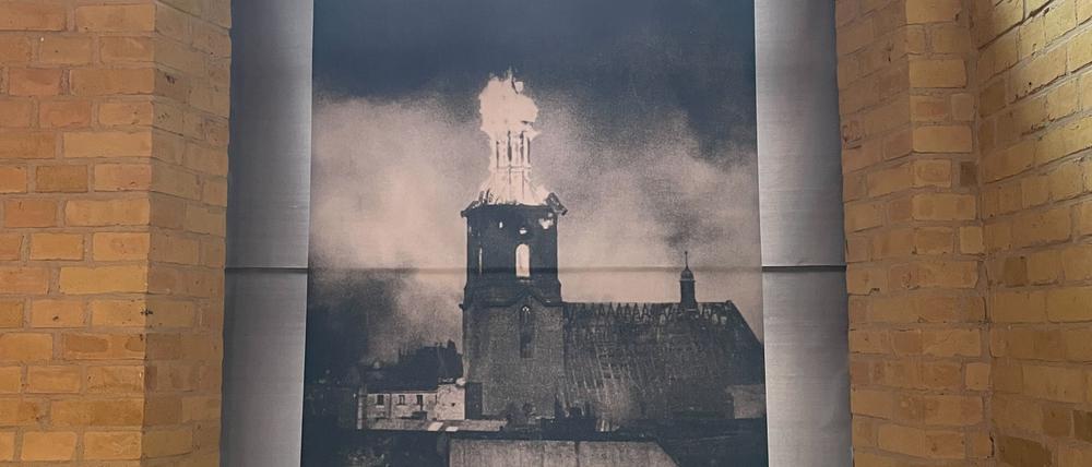 St. Nikolai, 1944, getroffen von Bomben. Der Kirchturm in der Altstadt in Flammen. Das Foto ist in der Zitadelle zu sehen.