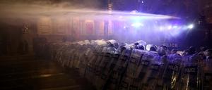 Polizeibeamte setzen einen Wasserwerfer ein.