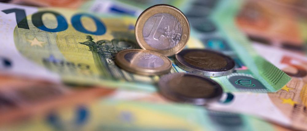 Geldscheine mit dem Wert von 100 und 50 Euro und Münzen liegen auf einem Tisch.