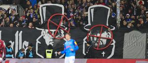 Banner im Kieler Fanblock zeigen die Gesichter von Oliver Mintzlaff und Jürgen Klopp mit einem Fadenkreuz darüber. 