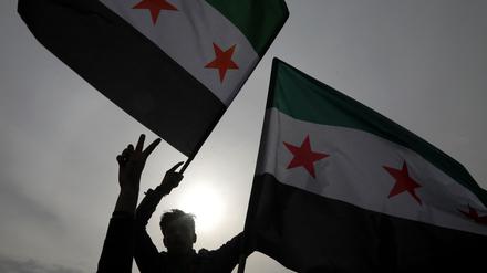Syrer schwenken am 8. Dezember 2024 in Arbil, der Hauptstadt der autonomen nordirakischen Kurdenregion, die Flagge der Opposition, während sie die Einnahme der Hauptstadt Damaskus durch die Rebellen feiern. 