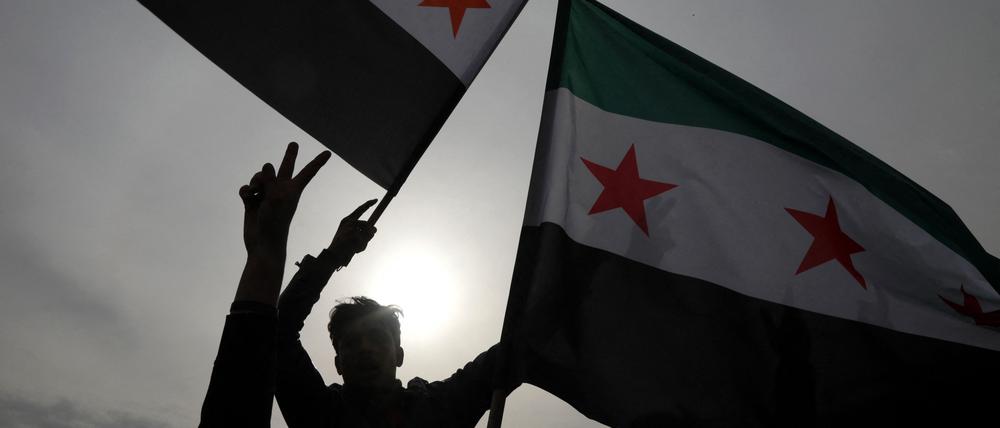 Syrer schwenken am 8. Dezember 2024 in Arbil, der Hauptstadt der autonomen nordirakischen Kurdenregion, die Flagge der Opposition, während sie die Einnahme der Hauptstadt Damaskus durch die Rebellen feiern.