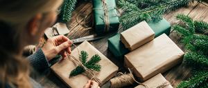 Eine Frau verpackt ein Weihnachtsgeschenk.