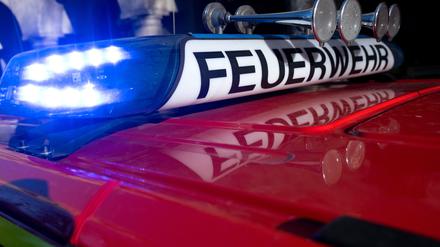 Ein Einsatzfahrzeug der Feuerwehr mit eingeschaltetem Blaulicht.