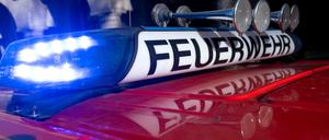 Ein Einsatzfahrzeug der Feuerwehr mit eingeschaltetem Blaulicht.