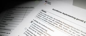 Ein schriftlicher Asylerstantrag des Bundesamts für Migration und Flüchtlinge (BAMF) liegt auf einem Tisch (gestellte Szene). 