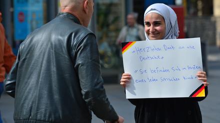 Ein Archivbild aus dem Jahr 2015: Eine junge Frau aus Syrien hält auf dem Anger in Erfurt (Thüringen) ein Schild mit der Aufschrift „Herzlichen Dank an alle Deutsche. Sie befinden sich im Herzen eines jeden syrischen Kind“ in den Händen.