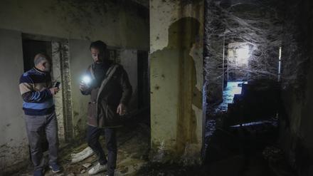 Zwei Männer inspizieren mit ihren Taschenlampen einen Korridor des berüchtigten Militärgefängnisses Saydnaya nördlich von Damaskus. Tausende von Insassen wurden nach dem Sturz des Regimes von Bashar al-Assad durch die Rebellen am Sonntag freigelassen, und einige hoffen, dort ihre Angehörigen zu finden.