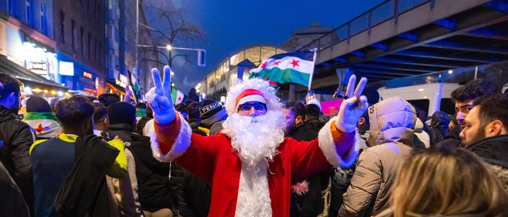 Tausende feiern am Sonntag, 8. Dezember 2024, in Berlin-Kreuzberg den Sturz Assads. EIn Weihnachtsmann steht mitten in der Kundgebung. 