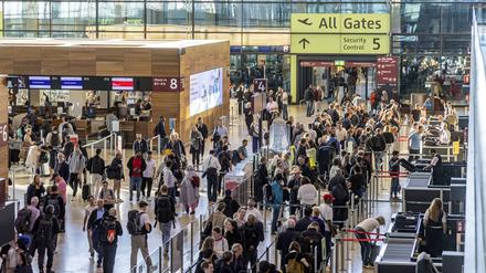 Passagiere im Terminal 1 warten vor dem Abflug auf Check-in und Sicherheitskontrolle. 