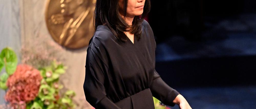 Han Kang mit ihrer Nobelmedaille und dem dazugehörigen Diplom.