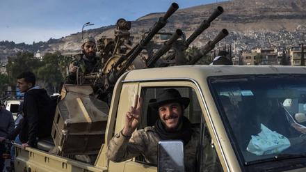 Ein syrischer Rebellenkämpfer zeigt nach dem Sturz von Assad das Friedenszeichen mit seinen Fingern.