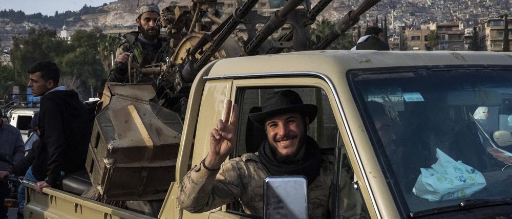 Ein syrischer Rebellenkämpfer zeigt nach dem Sturz von Assad das Friedenszeichen mit seinen Fingern.