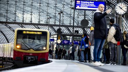 Reisende warten bei einem S-Bahn-Zug am Berliner Hauptbahnhof.